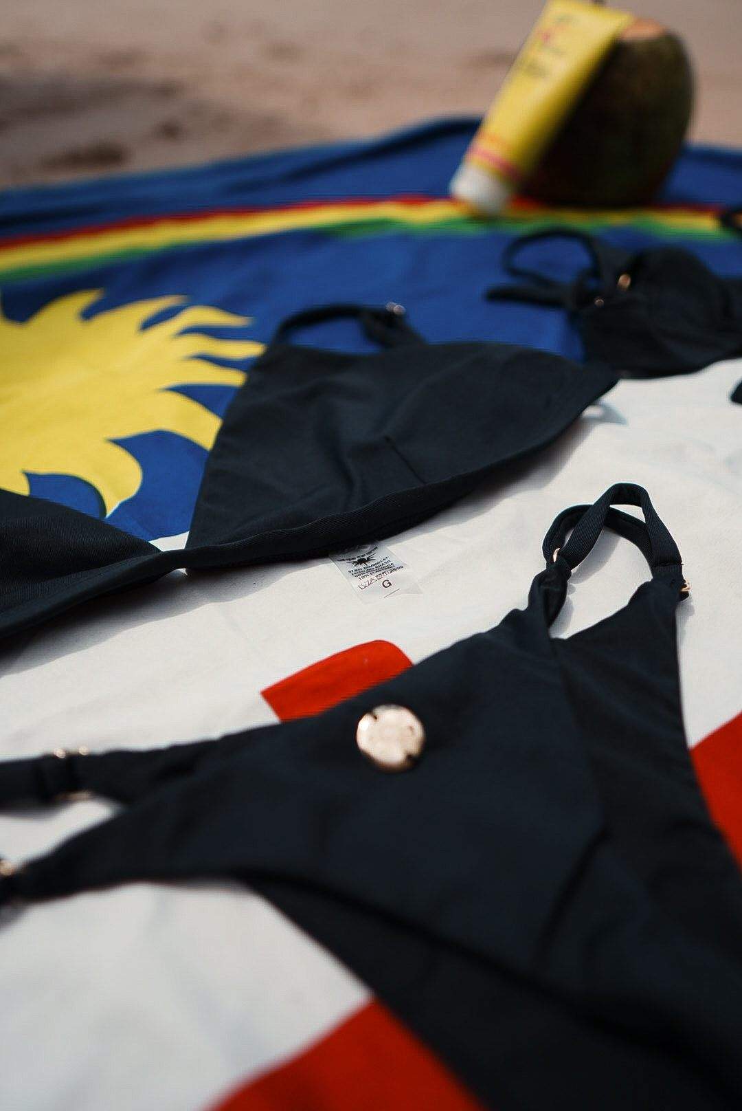 Conjunto preto sobre a bandeira de Pernambuco, na areia